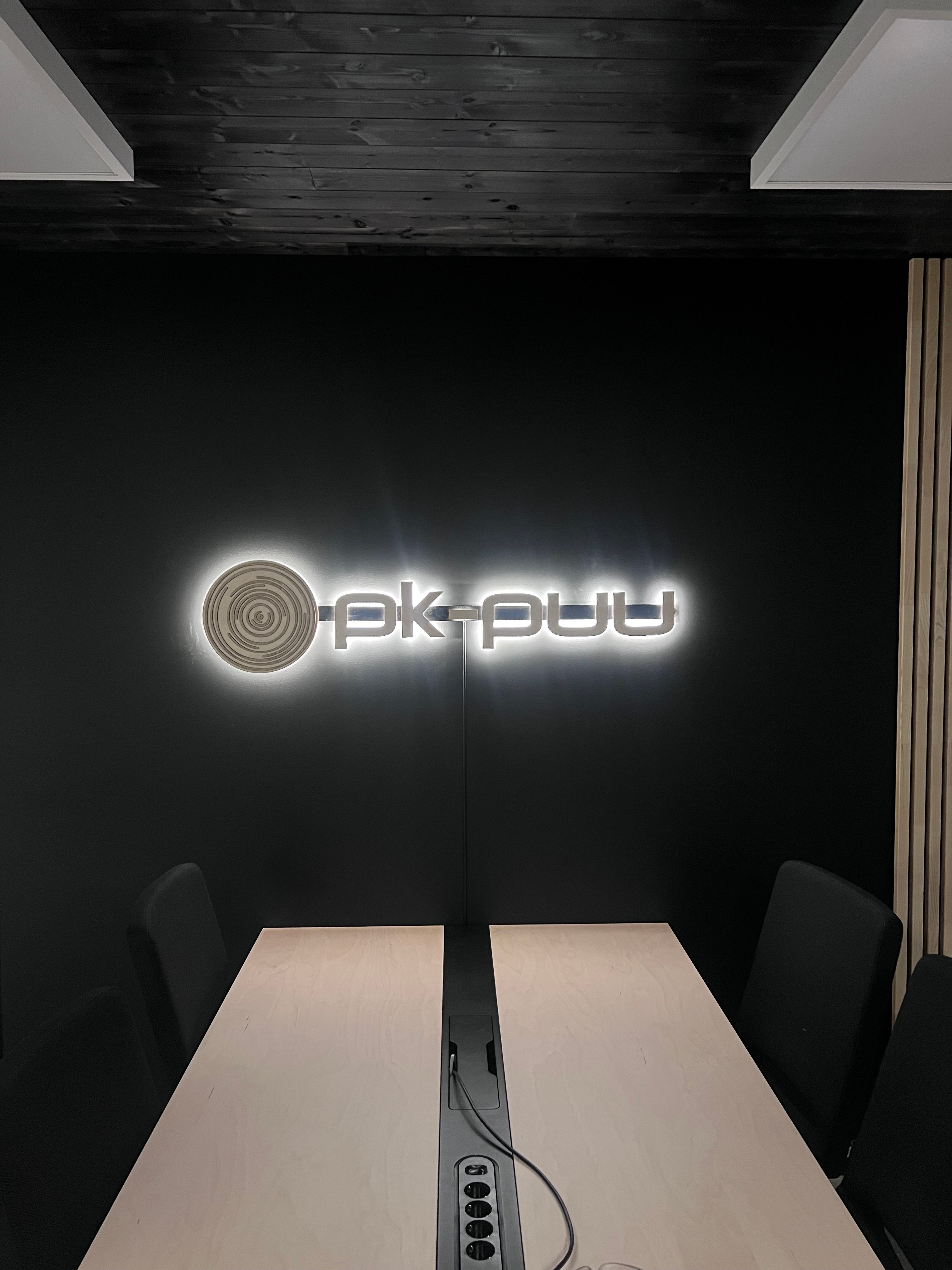 Valaistu logo vanerista PK-Puun neuvotteluhuoneeseen